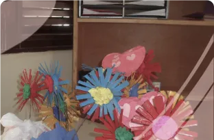 Colorful paper flowers in blue, red, pink, yellow, and green arranged in a bouquet.