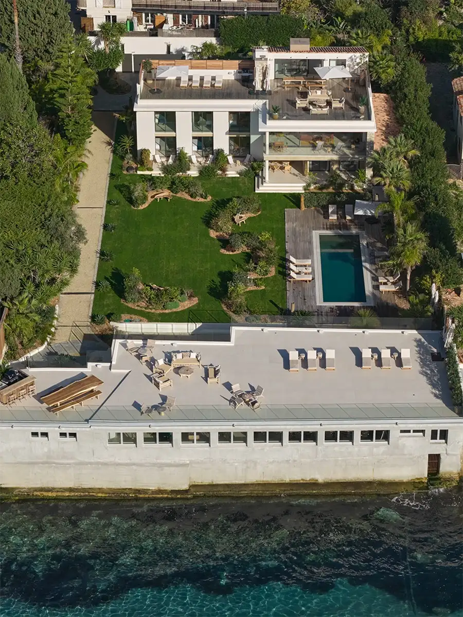 Vue aérienne de la villa l'île verte, son jardin, piscine mirroir, terrasse aménagée et vue sur la mer méditerannée.
