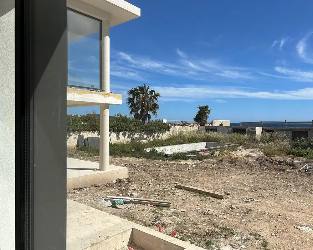 Terrain brut et jardin non aménagé avec vue mer avant création des espaces extérieurs de La Villa L’Île Verte