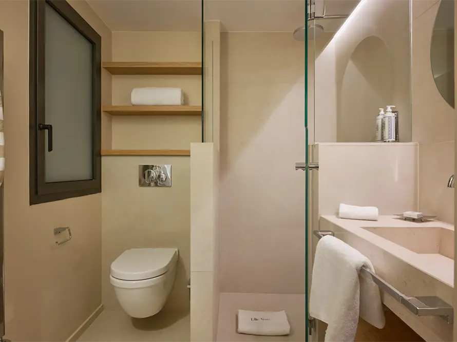 Salle de bain design de la chambre 1 – villa de luxe La Villa L’Île Verte à La Ciotat avec double vasque, miroir rond et matériaux haut de gamme