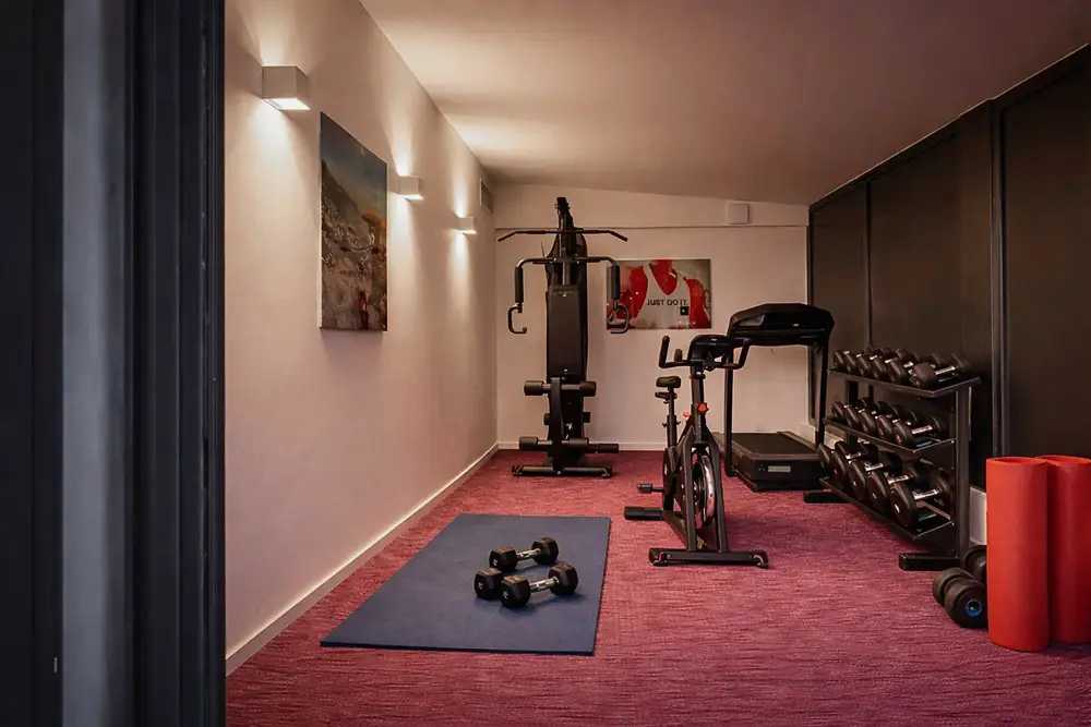salle de sport entièrement équipée avec espace yoga, haltères, vélo d’appartement, tapis de course, machines de musculation et accessoires bien-être dans la villa de luxe L’Île Verte à La Ciotat en Méditerranée