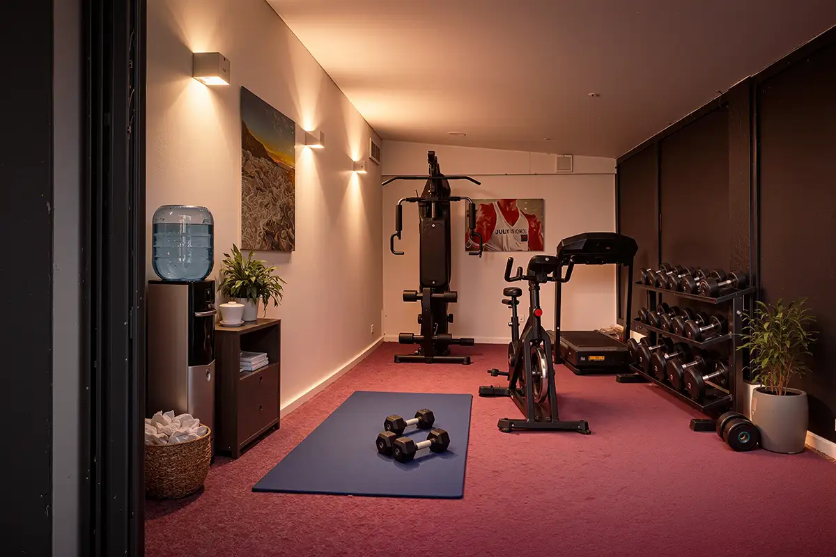 salle de sport entièrement équipée avec espace yoga, haltères, vélo d’appartement, tapis de course, machines de musculation et accessoires bien-être dans la villa de luxe L’Île Verte à La Ciotat en Méditerranée