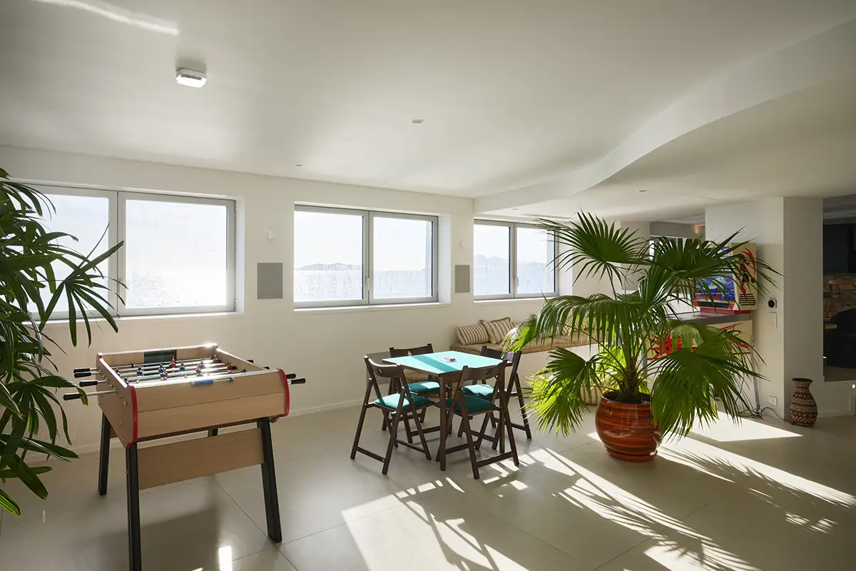 business center moderne avec grande table de réunion en bois et chaises noires, baigné de lumière naturelle avec vue mer dans le pavillon de la villa de luxe L’Île Verte à La Ciotat