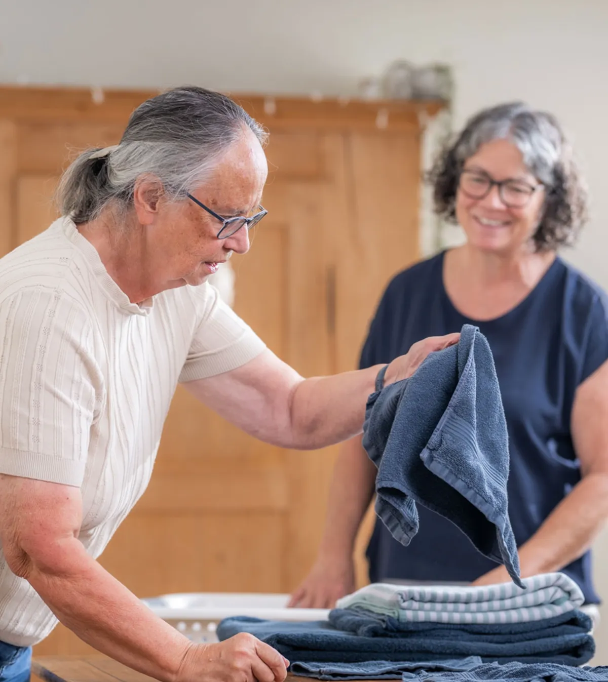 Zwei Frauen am Wäsche zusammenlegen
