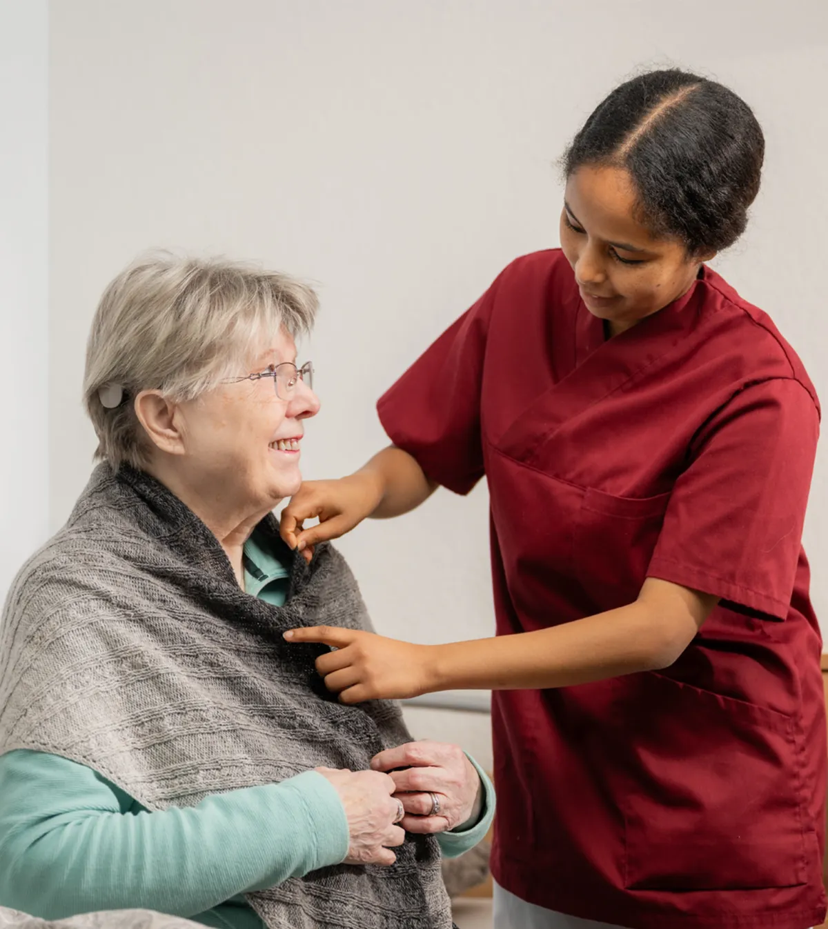 Eine Hand wird von jemandem aus der Pflege verarztet