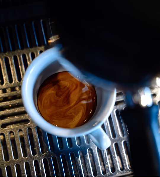 Frisch gebrühter Espresso in einer weißen Tasse an der Siebträgermaschine