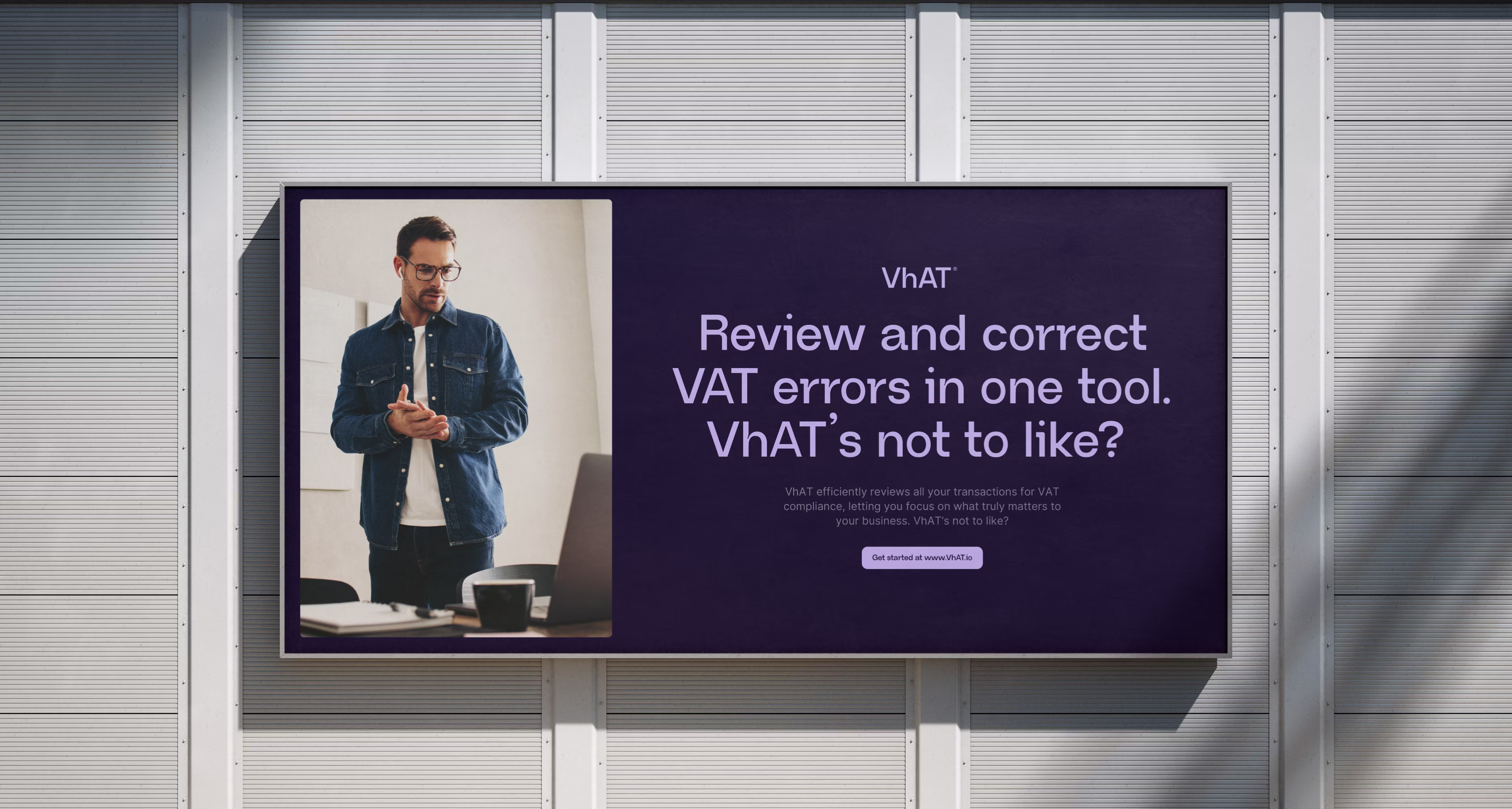 Udendørs billboard med mand i briller og denimskjorte samt tekst der promoverer VhAT til gennemgang og rettelse af momsfejl i ét værktøj.