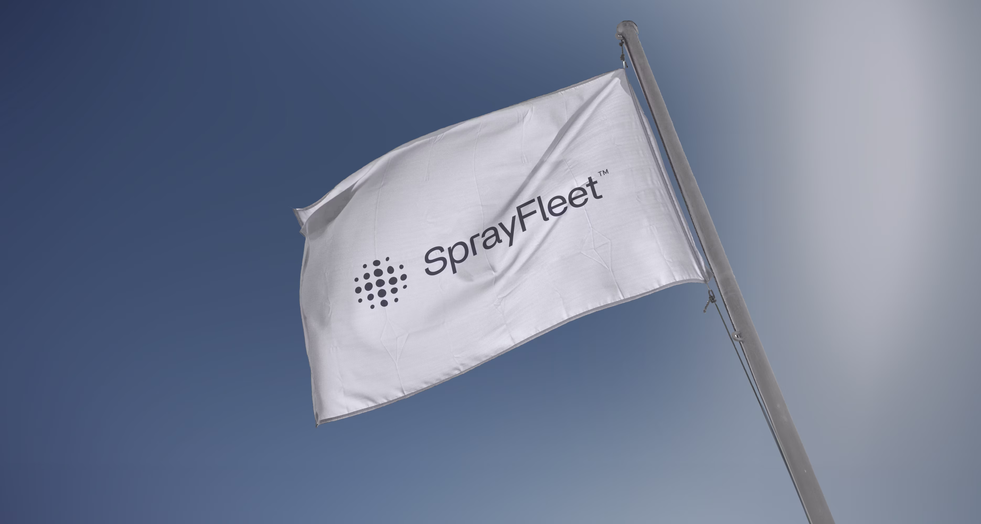 Hvidt flag med sort SprayFleet-logo der vajer mod blå himmel.