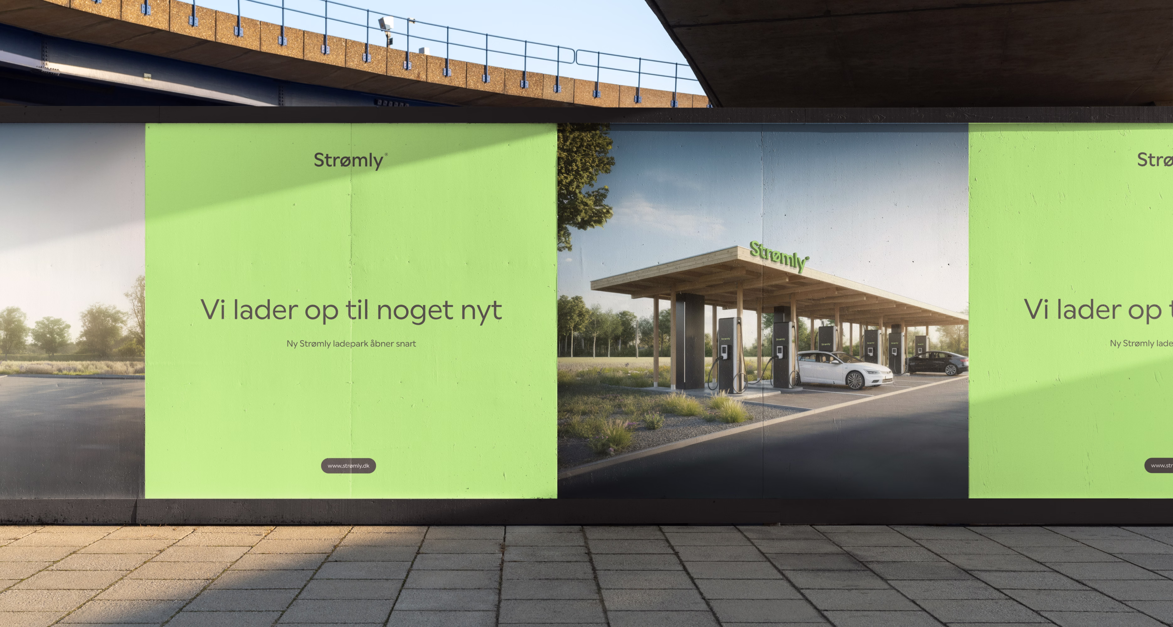 Hænder der holder en tablet med en hjemmeside, hvor en sort Strømly-enhed er monteret på en træoverflade.