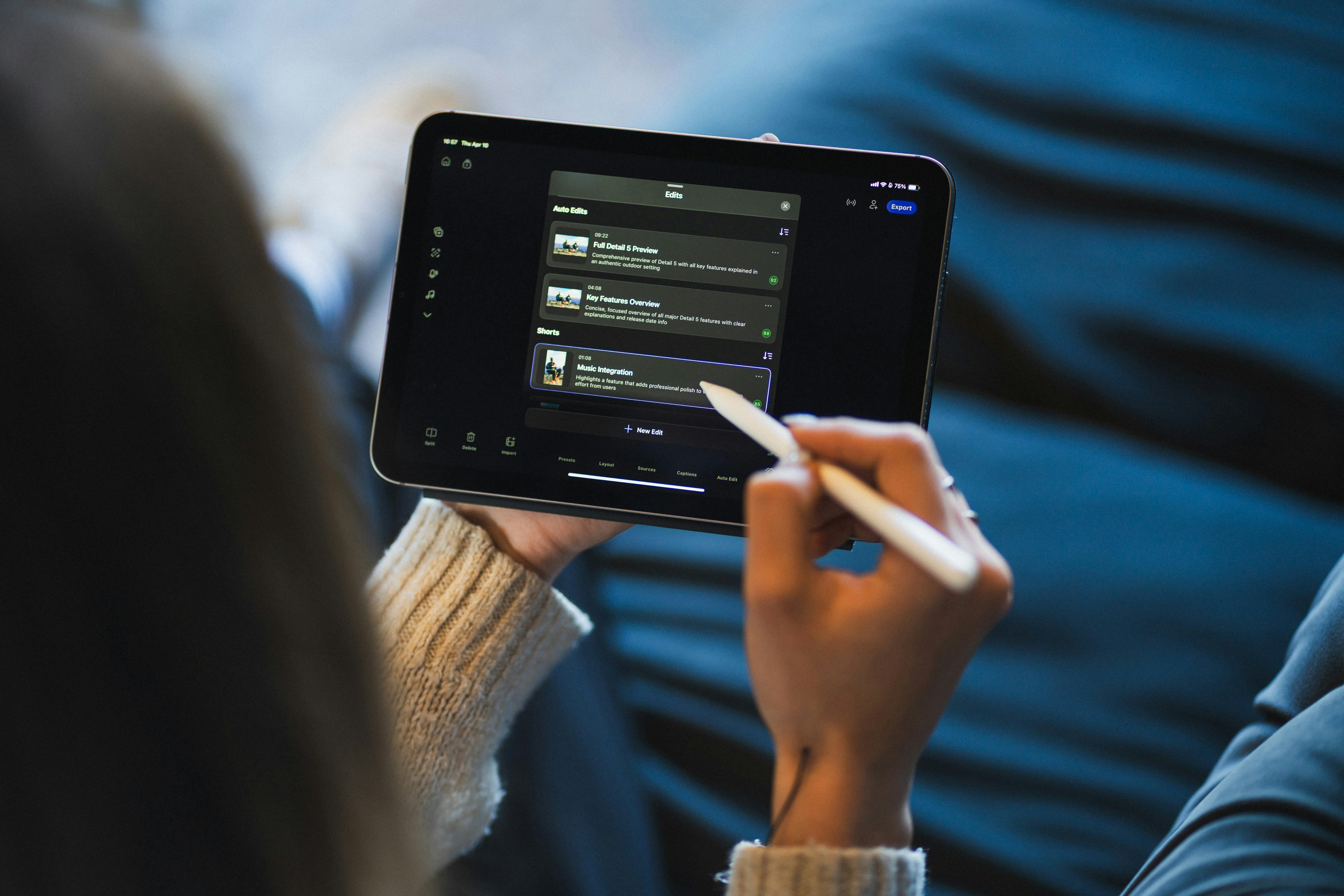 Person using a stylus to interact with a video editing app on a tablet screen.