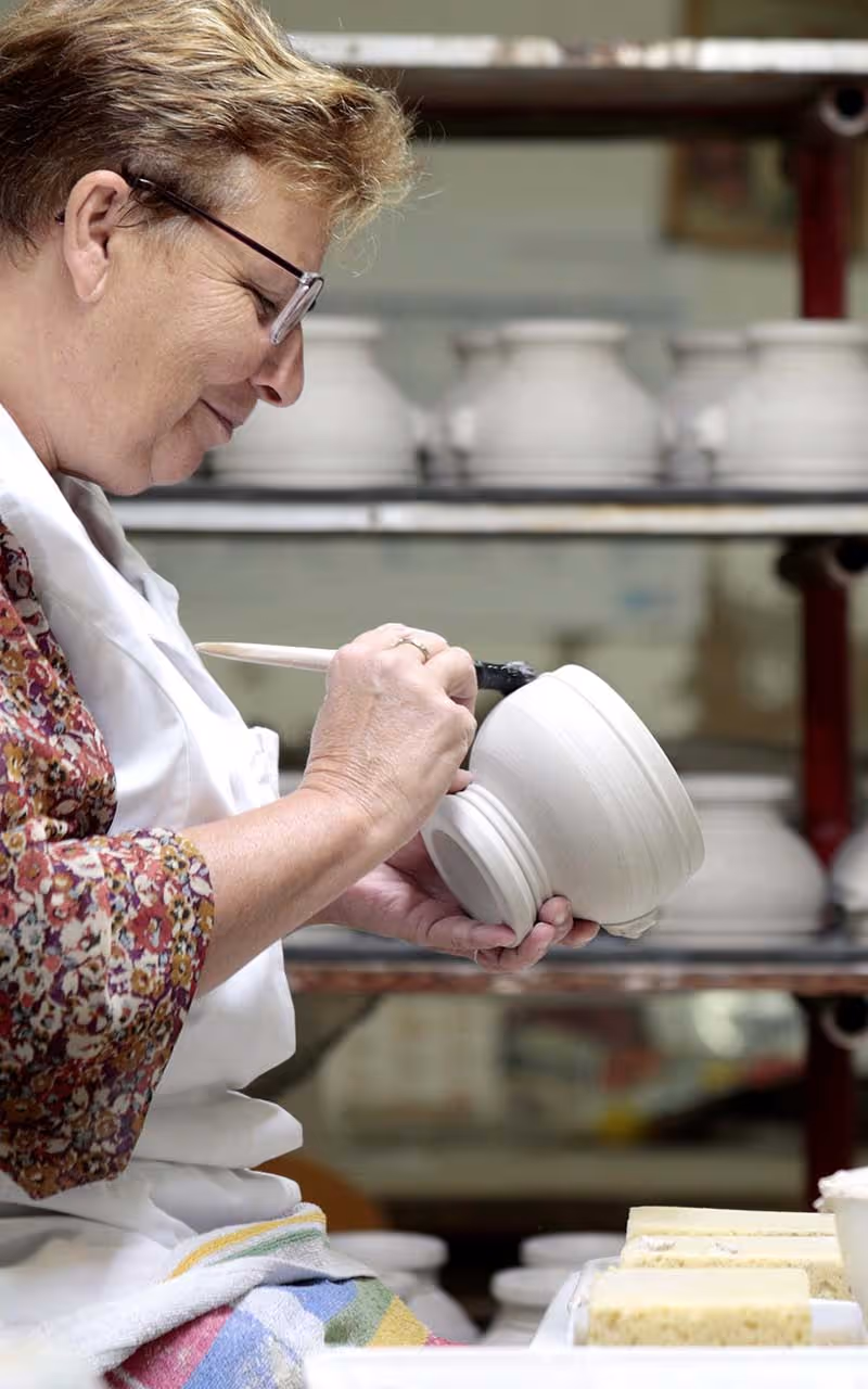 Artisan Pillivuyt faconne  un pot en porcelaine blanc dans un atelier de porcelaine en France.