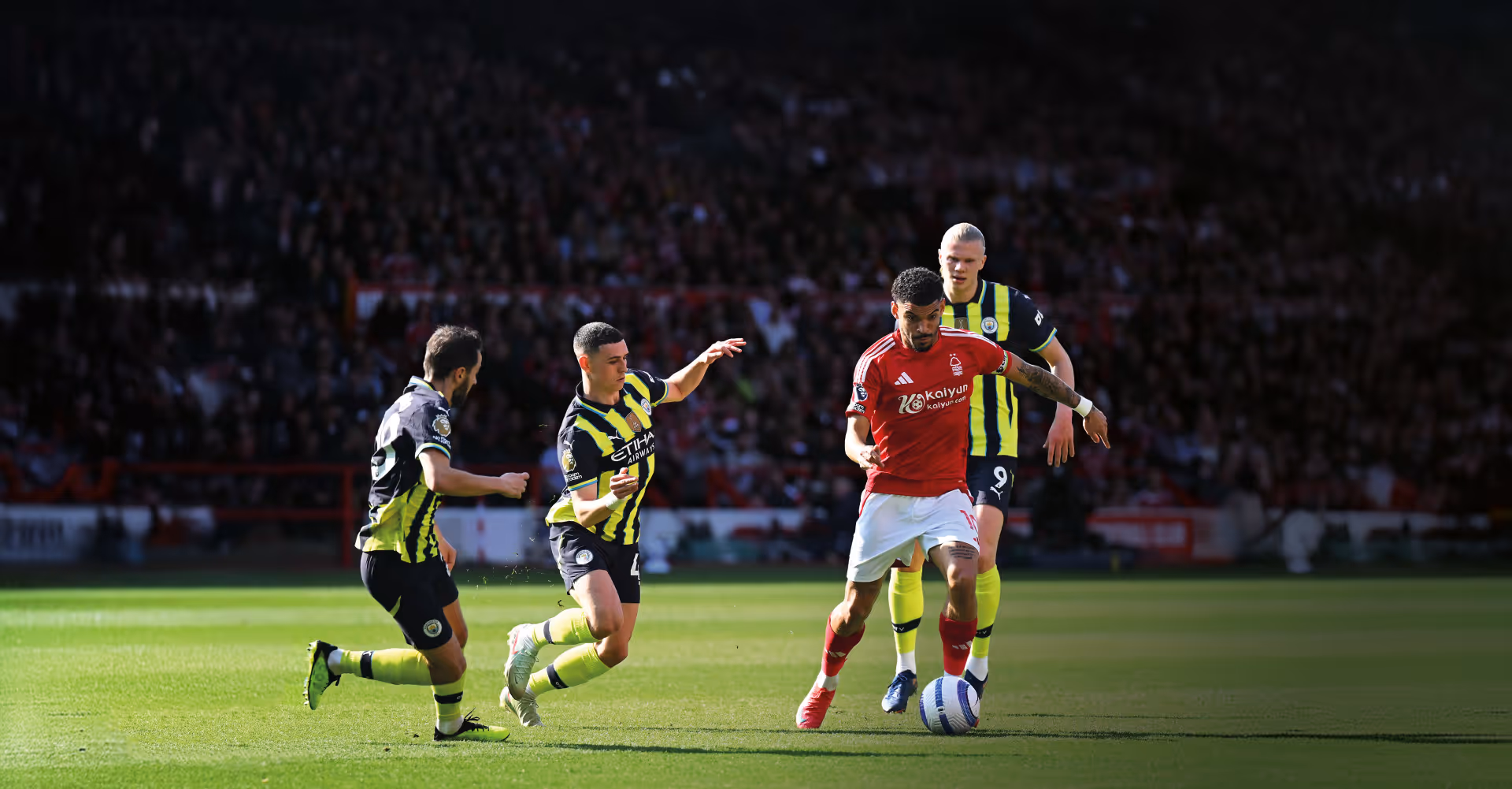Manchester City player Phil Foden attempts to tackle Nottingham Forest's Morgan Gibbs-White while Erling Haaland and Bernardo Silva watch on.