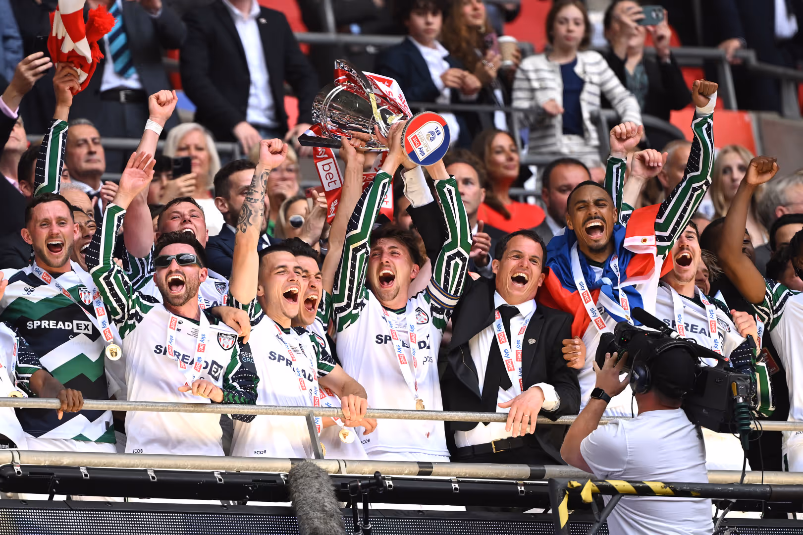 Sunderland players lift the Championship Play-Off trophy while cheering.