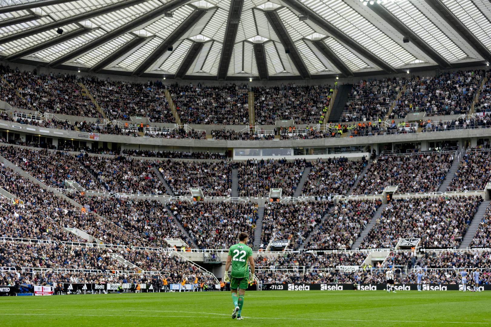 Newcastle United goalkeeper Nick Pope stands on the pitch with a large crowd at St James' Park watching.