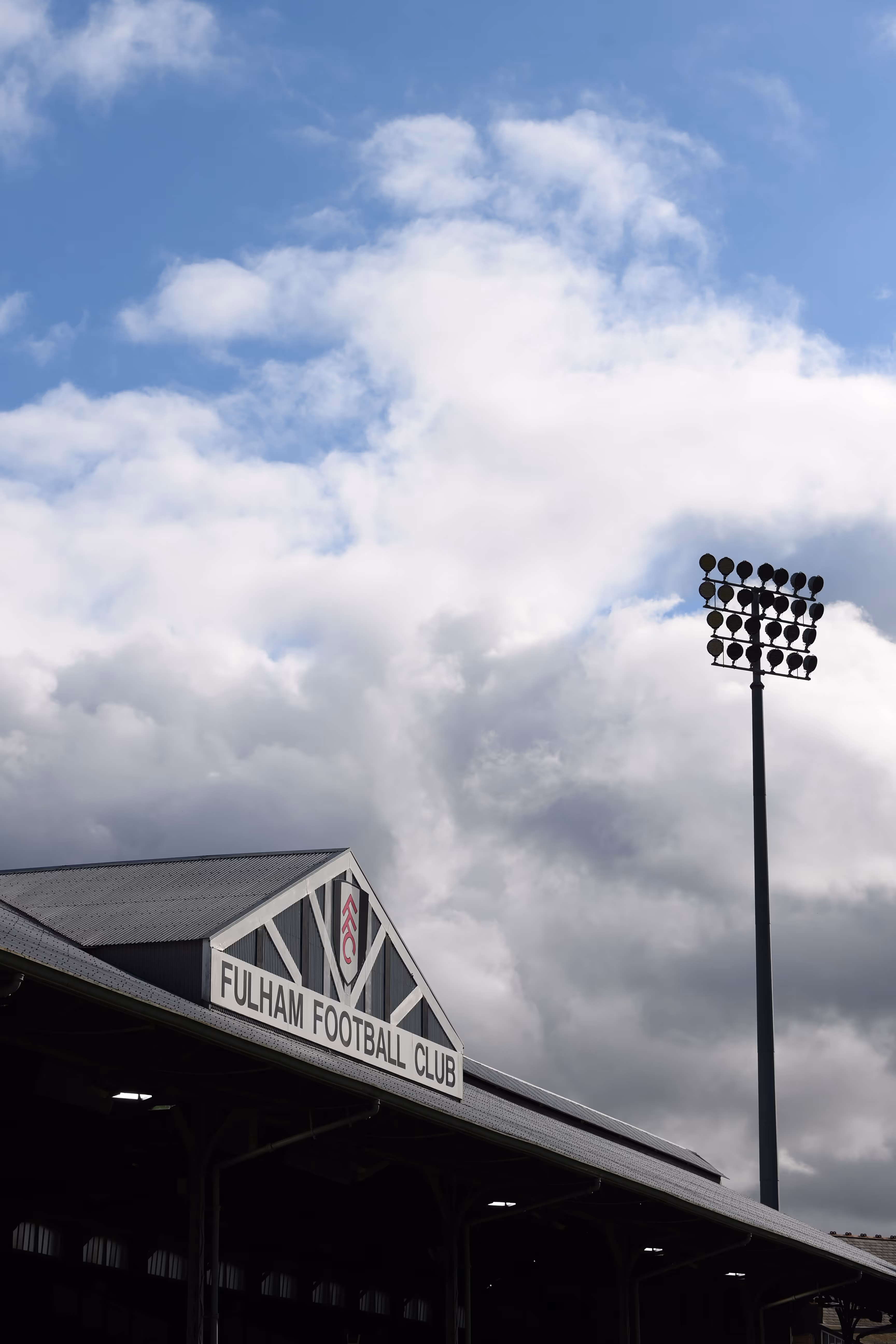 Fulham Football Club stadium and lights under a cloudy sky.