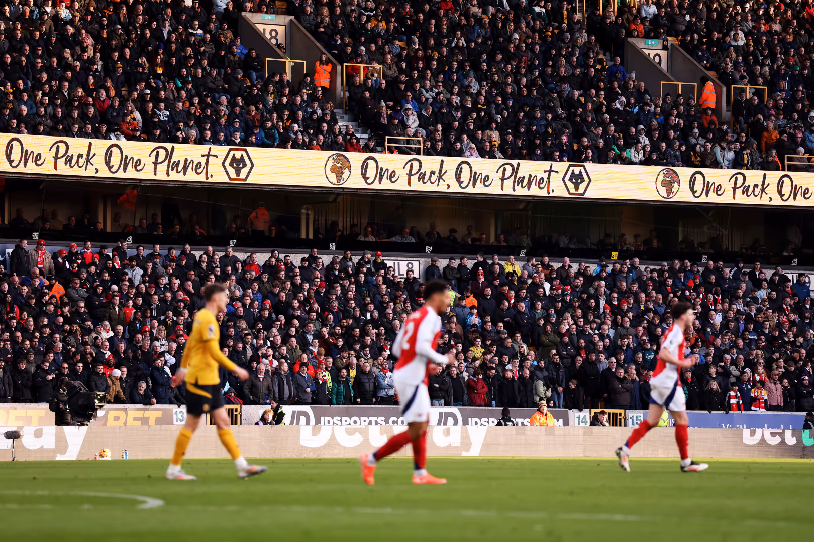 Wolves and Arsenal players in front of a banner reading One Pack One Planet.