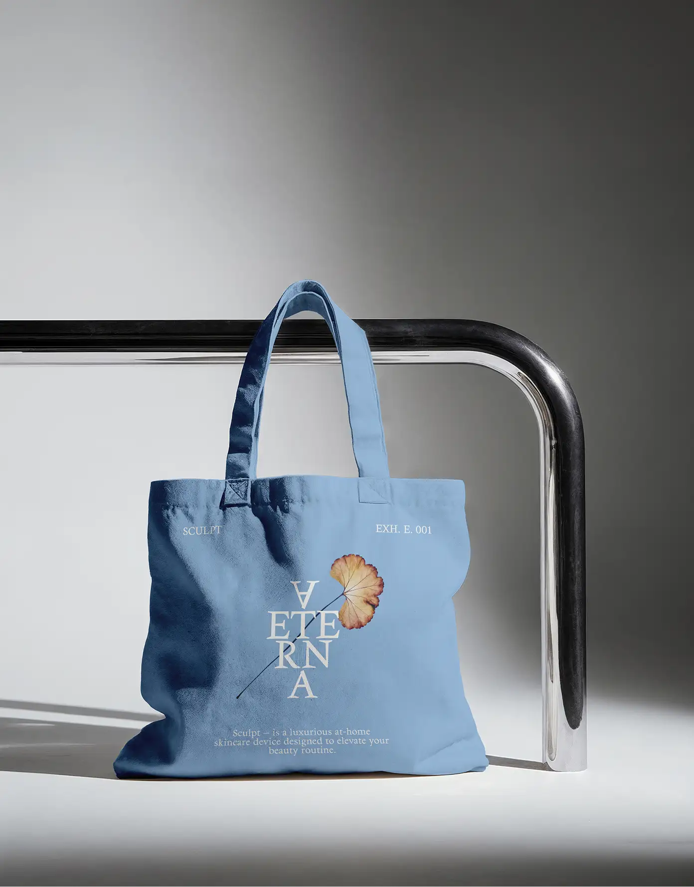 Mineral-blue tote — stacked Aeterna lettermark and flower