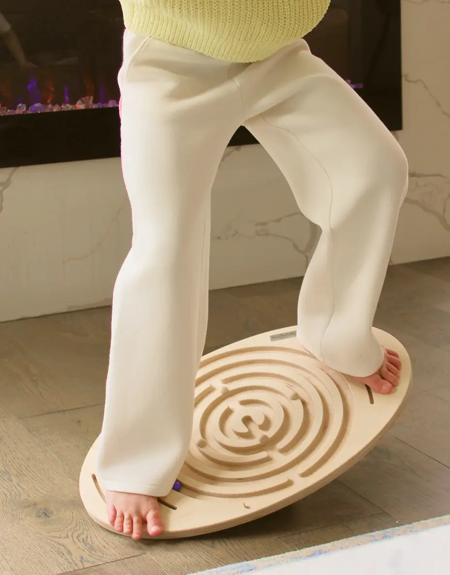 Child balancing on wooden balance board