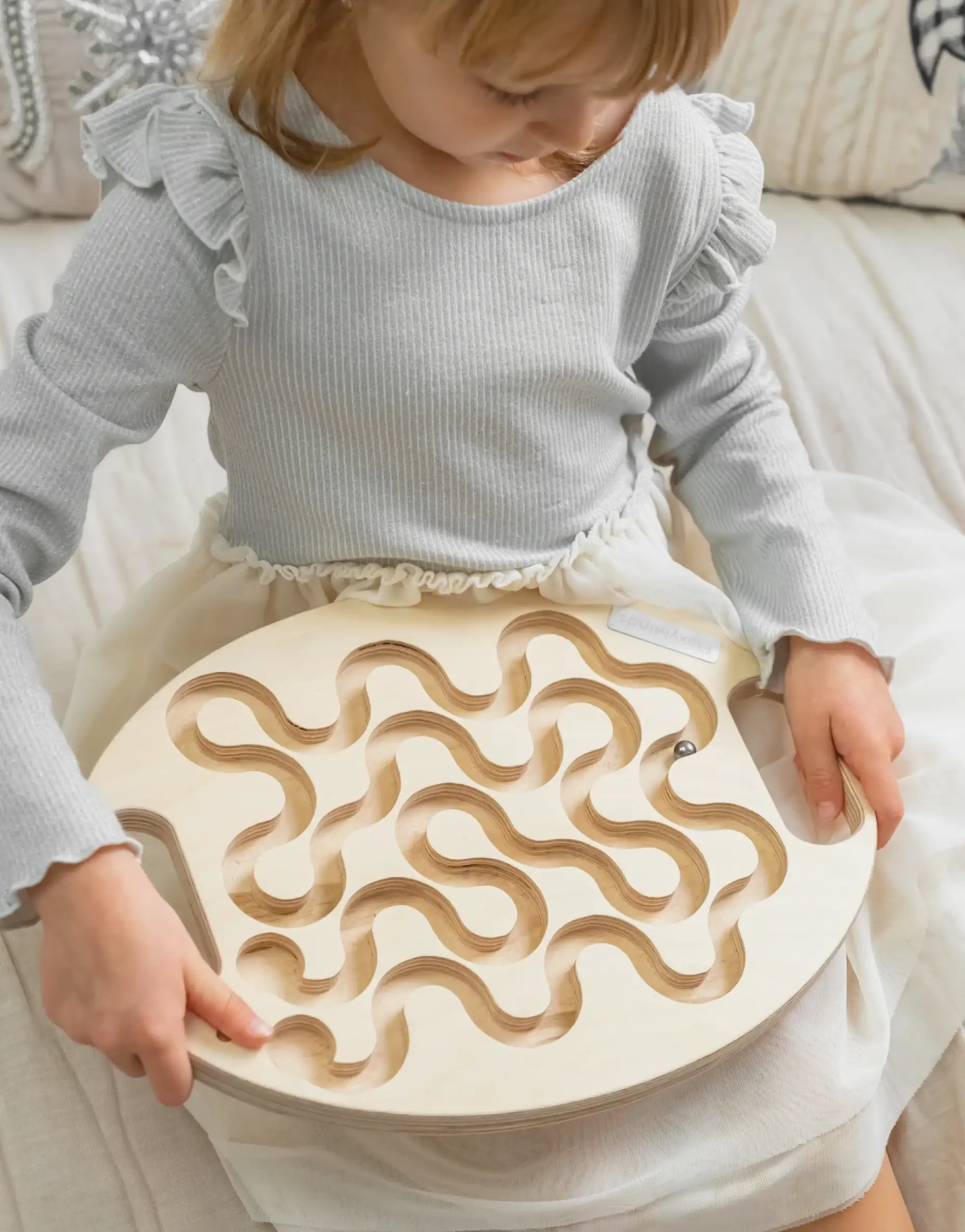 Child playing with wooden maze toy
