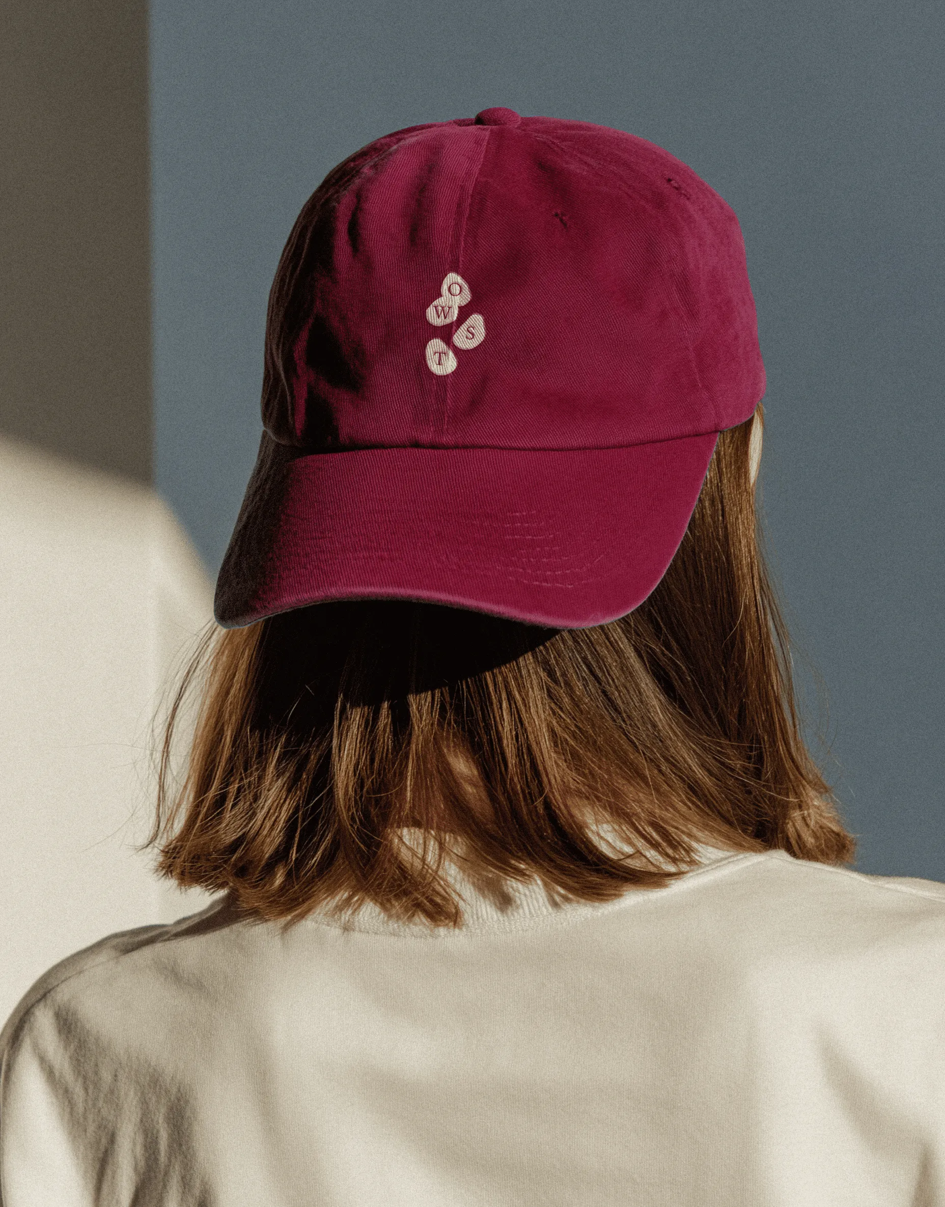 Burgundy cap embroidered with the On Way Storytellers mark.