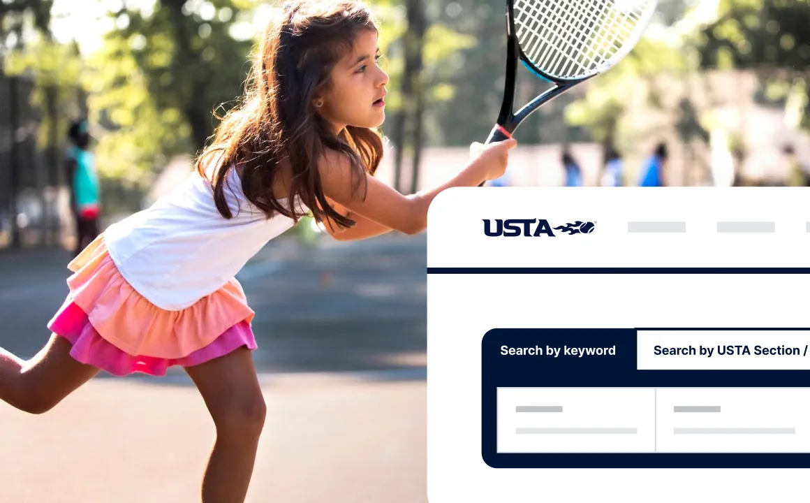 Young girl in a white top and pink skirt playing tennis outdoors, holding a racket mid-swing.