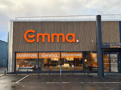 Exterior of Emma store with large orange logo and windows displaying furniture inside.