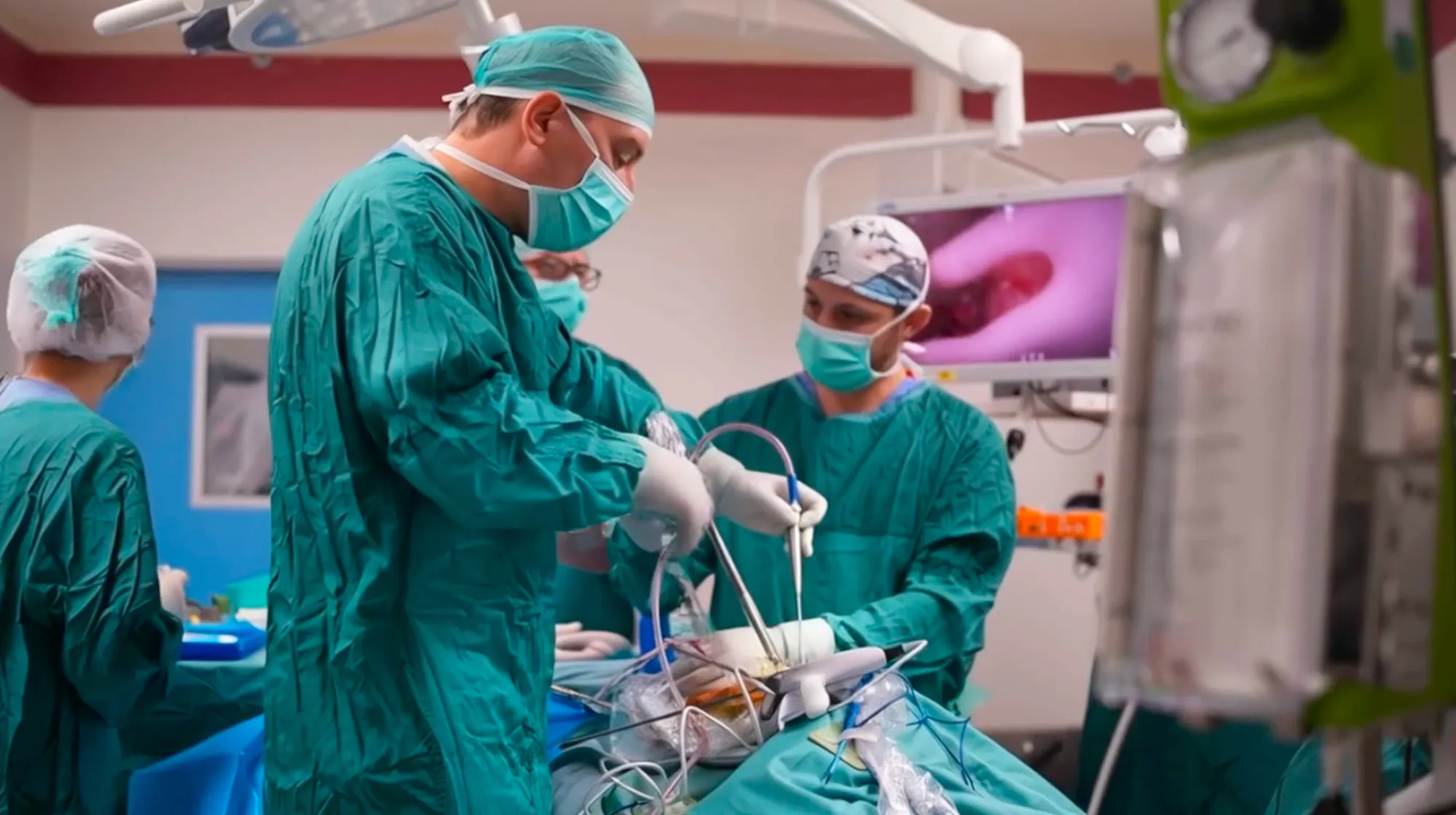Photo of a team of surgeons wearing scrubs, operating on a patient