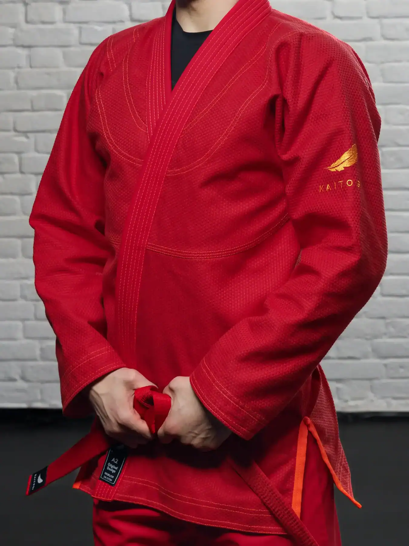 Фактура красного кимоно KAITOGI: оранжевая вышивка и строчка на куртке крупным планом