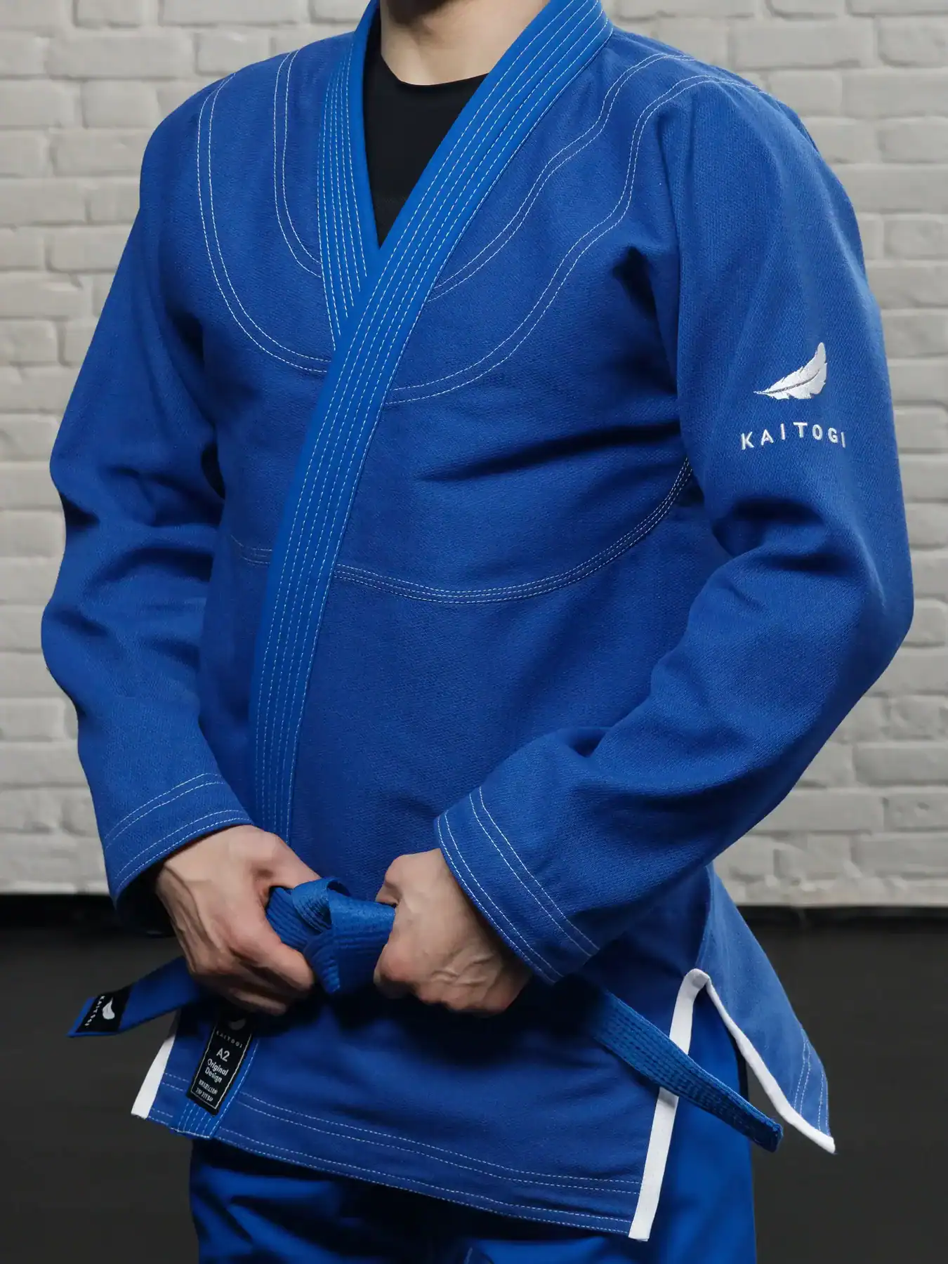 Текстура синего кимоно KAITOGI: белая вышивка и прочные швы на куртке крупным планом