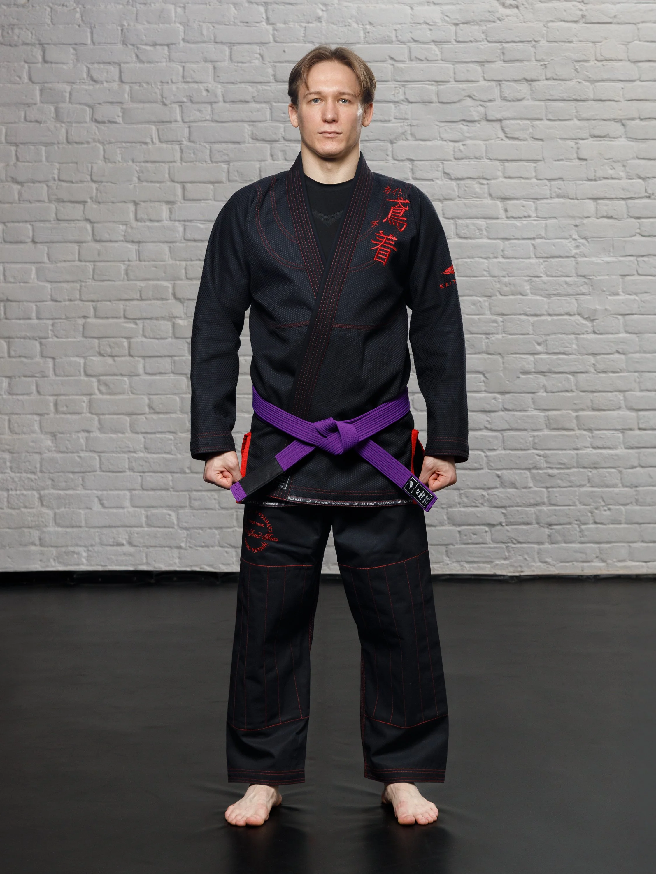 Кимоно для бразильского джиу-джитсу черного цвета с красными элементами на модели анфас