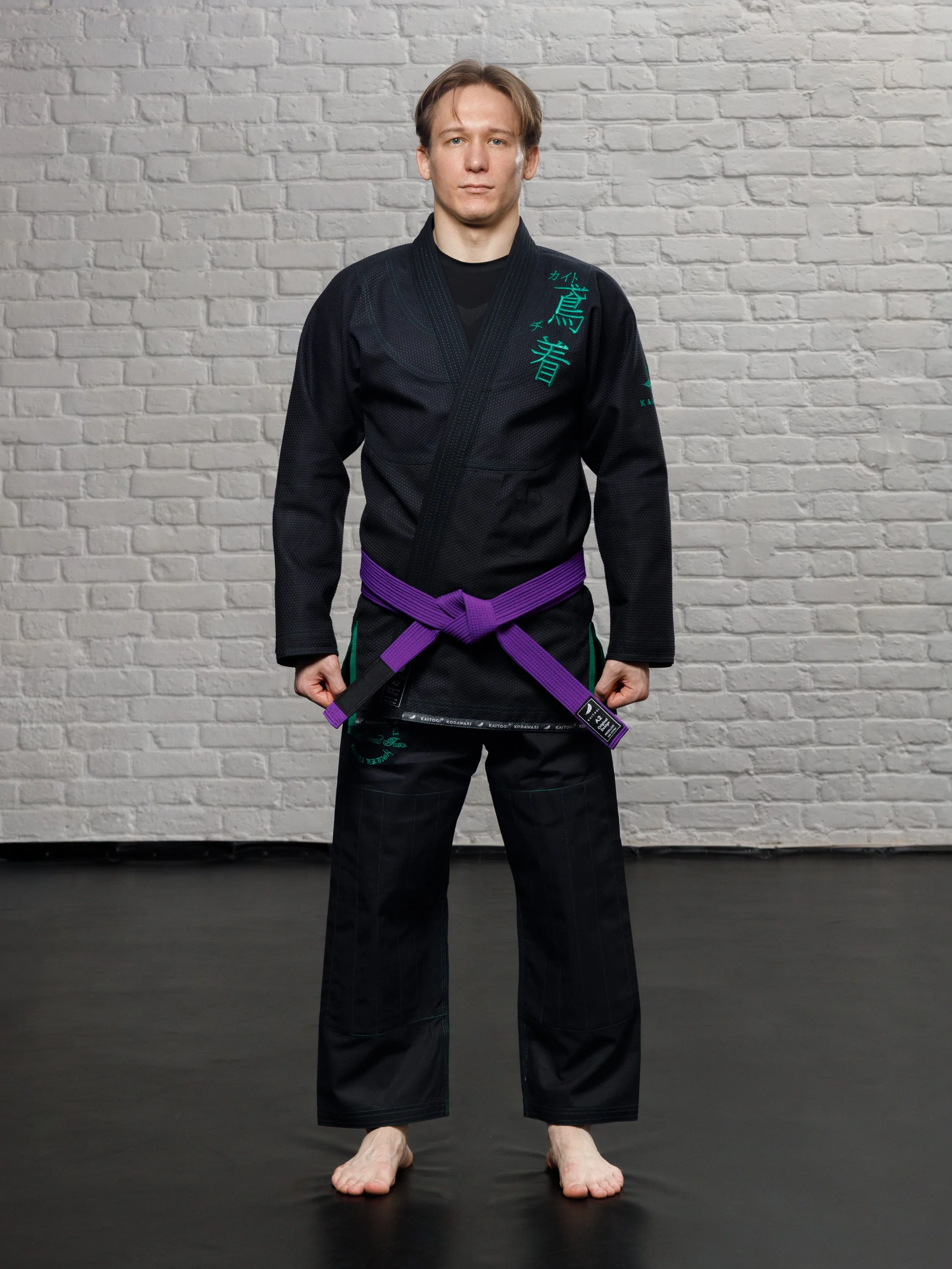 Модель в черном ги с зеленым дизайном в полный рост, анфас