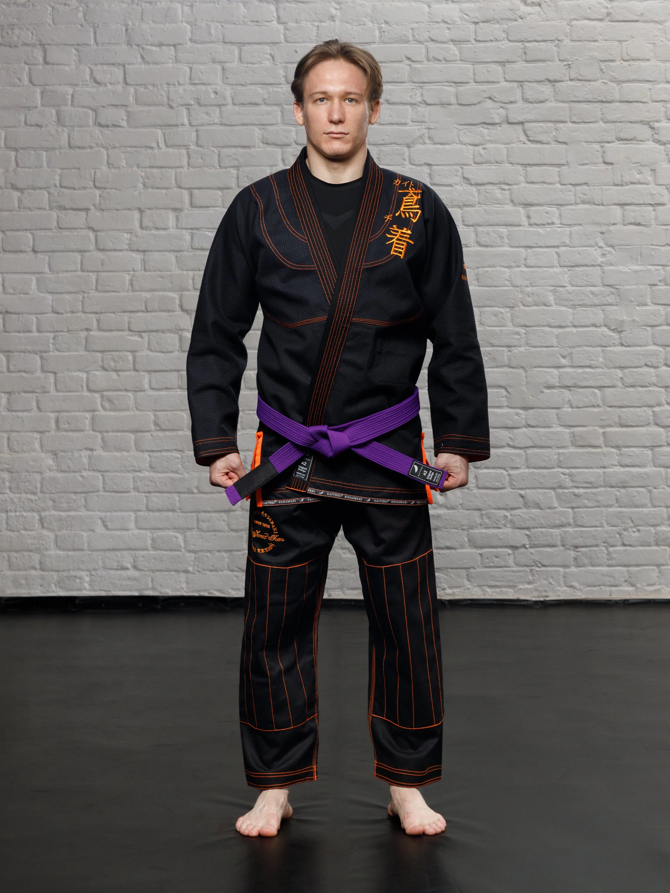 Черное ги с оранжевыми элементами на модели в полный рост