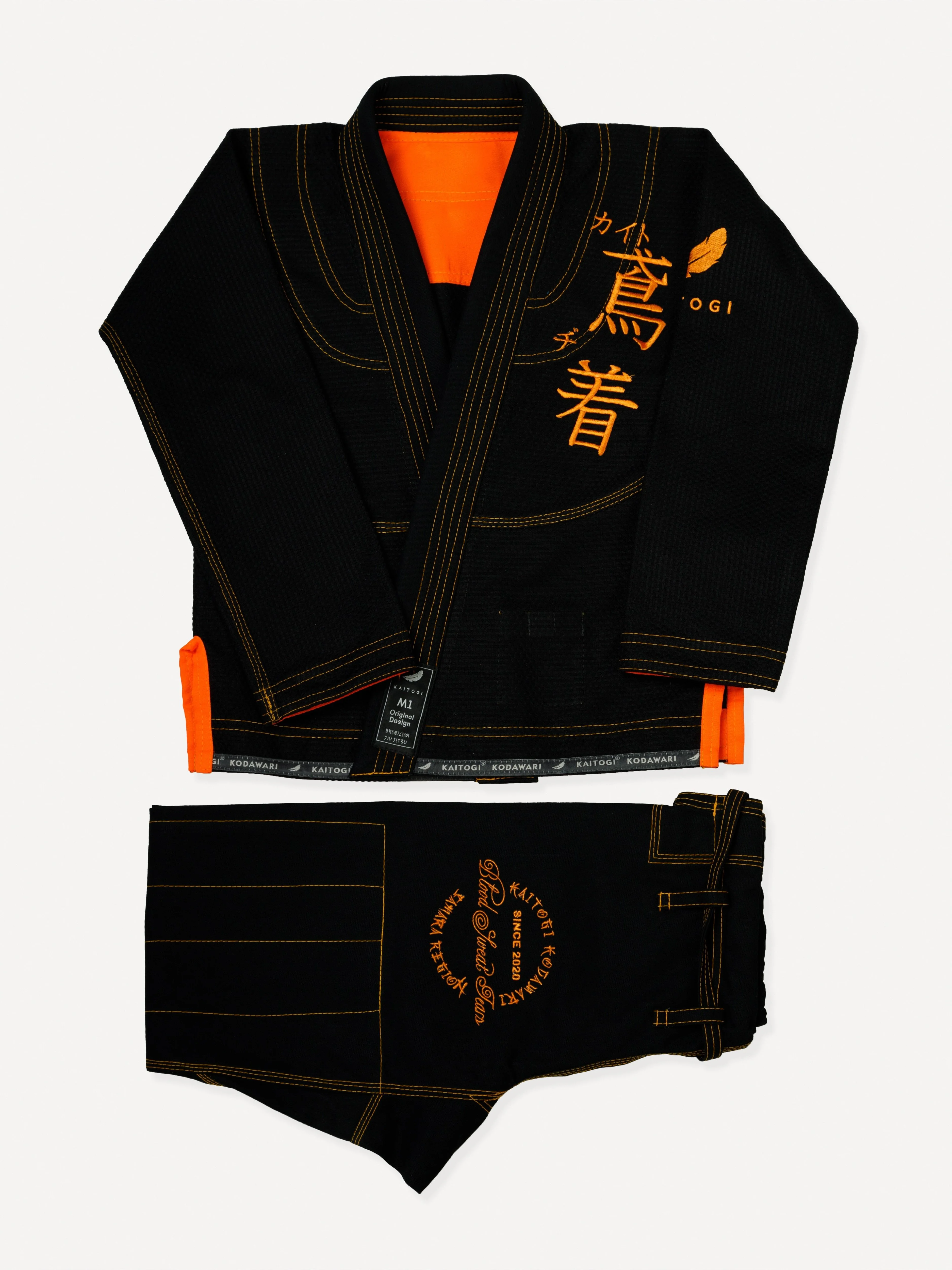 Сложенный комплект черного кимоно с оранжевой отделкой