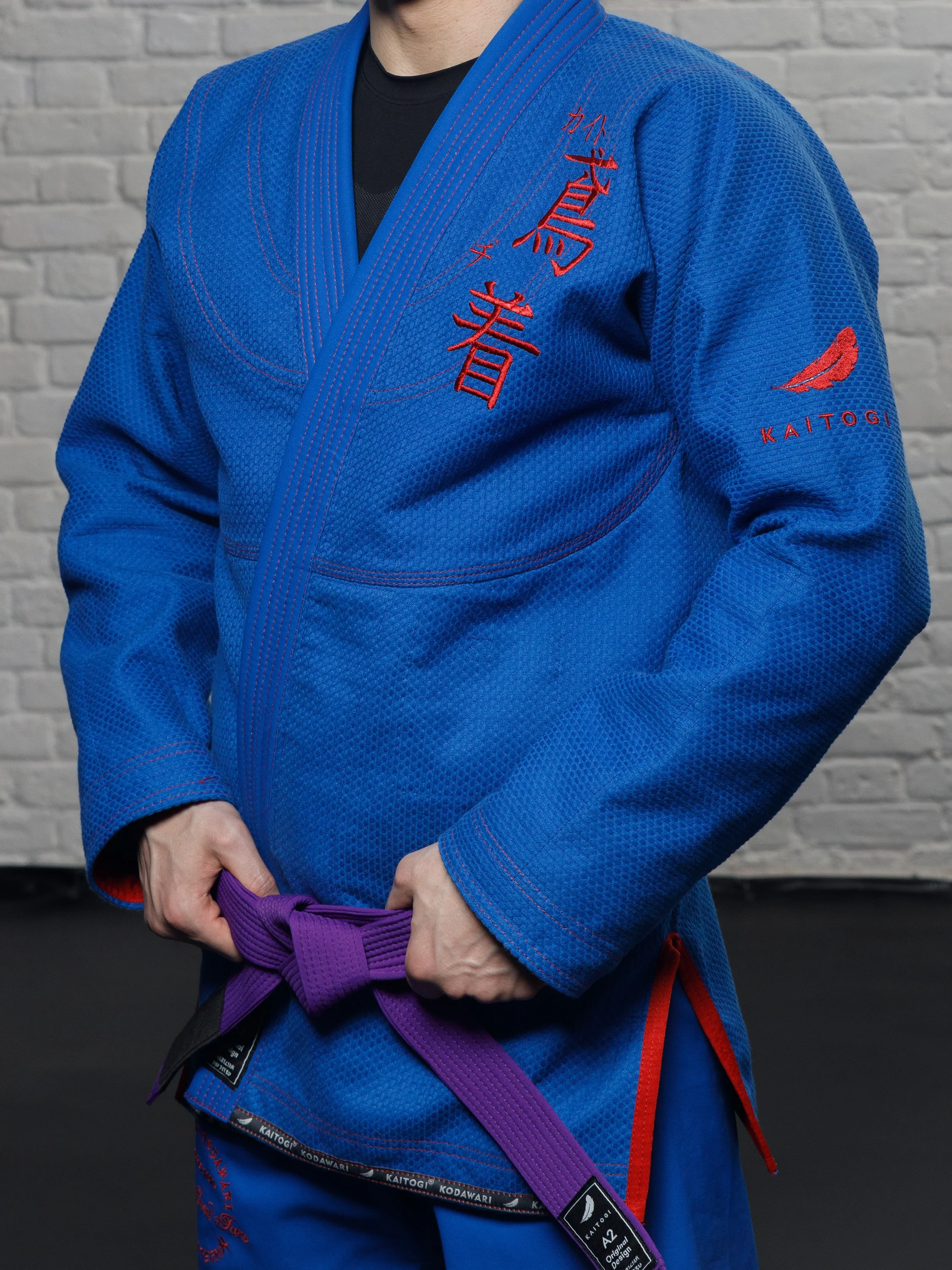 Крупный план синей куртки ги KAITOGI с красной вышивкой и логотипом