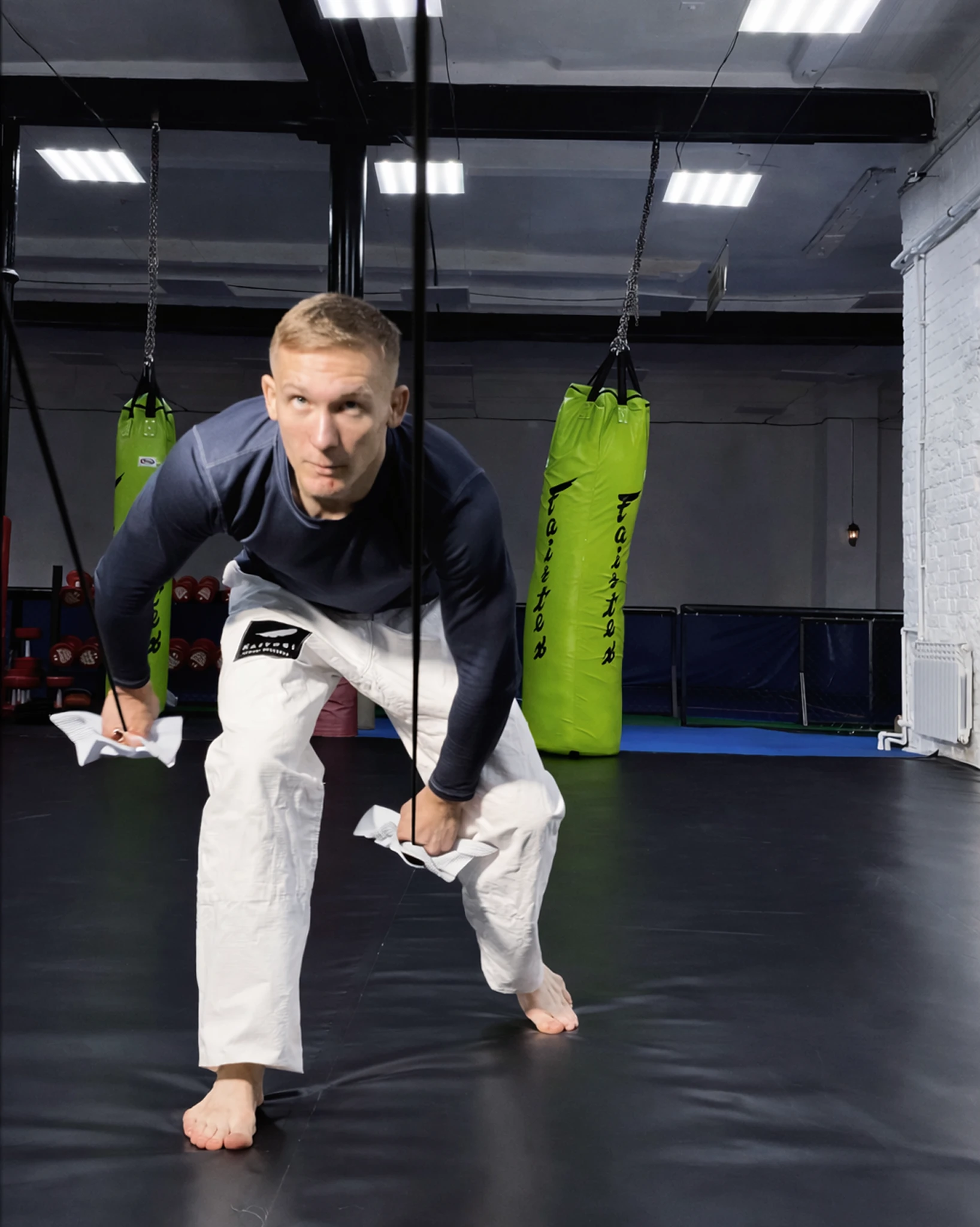 Силовое упражнение: тяга белой борцовской резины вниз для укрепления предплечий