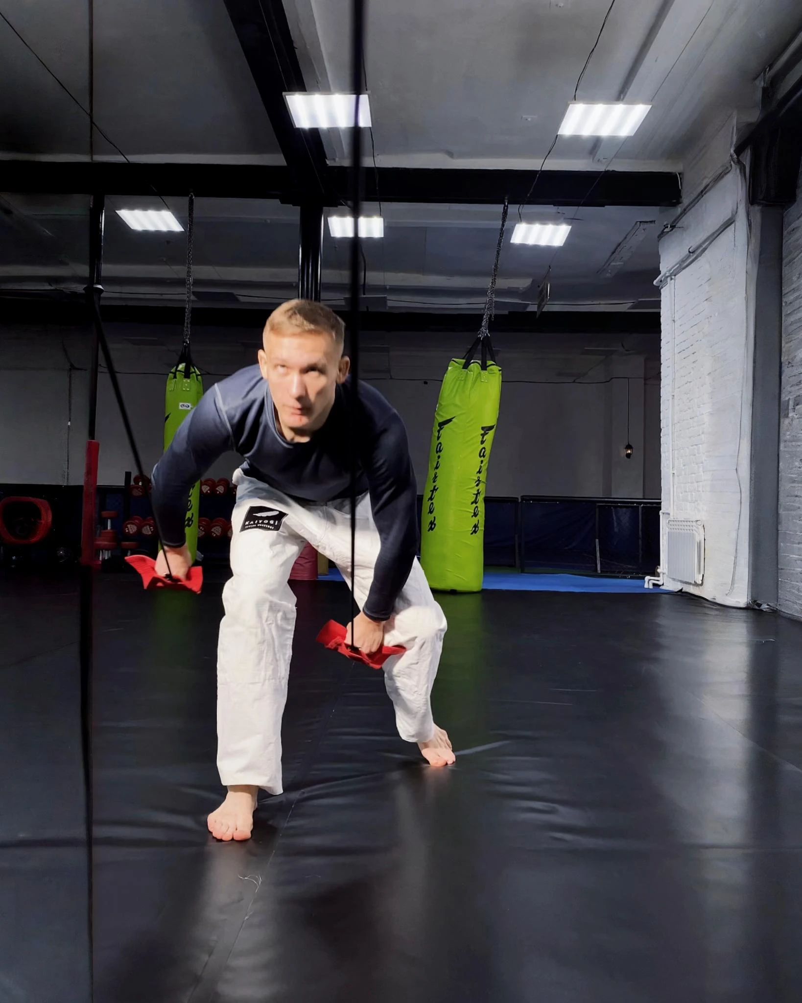 Тяга красного тренажера вниз для укрепления хвата взрослого спортсмена