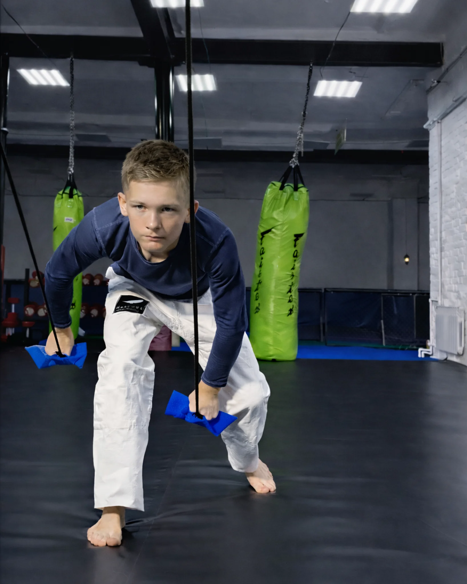 Тренировка хвата: ребенок тянет синюю резину Учикоми вниз