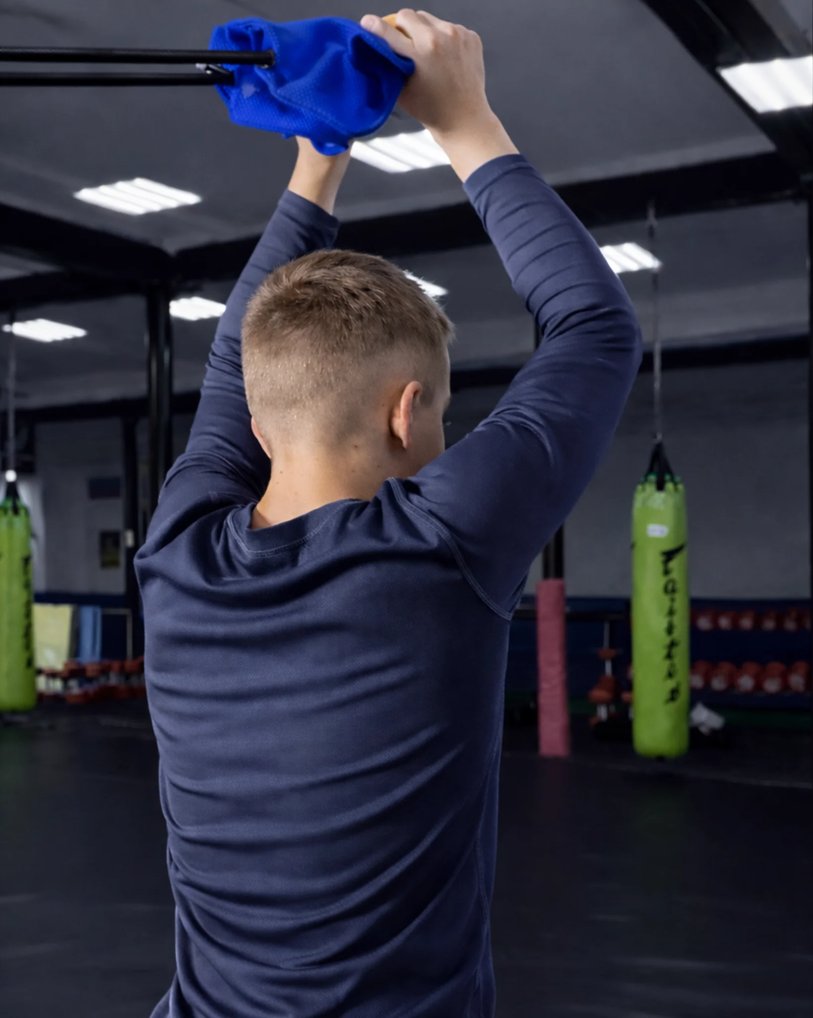 Упражнение на спину: тяга синей детской резины-отворота со спины