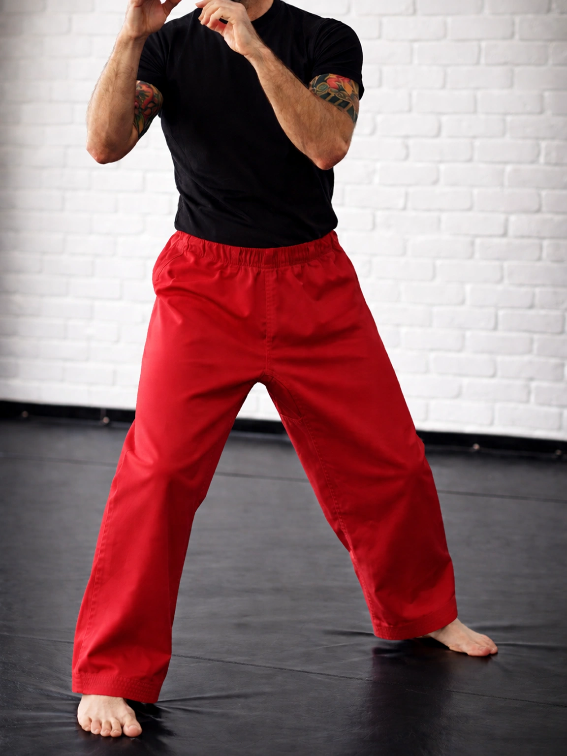 Красные штаны М2 на резинке на спортсмене: демонстрация посадки на талии и длины штанин ниже щиколотки