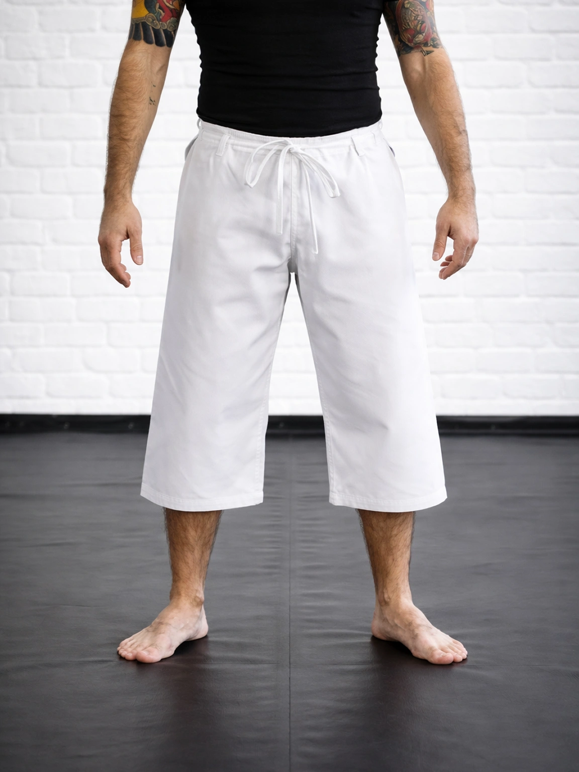 Белые тренировочные бриджи М4 (ниже колена) на спортсмене: традиционная фиксация завязками и свобода движений