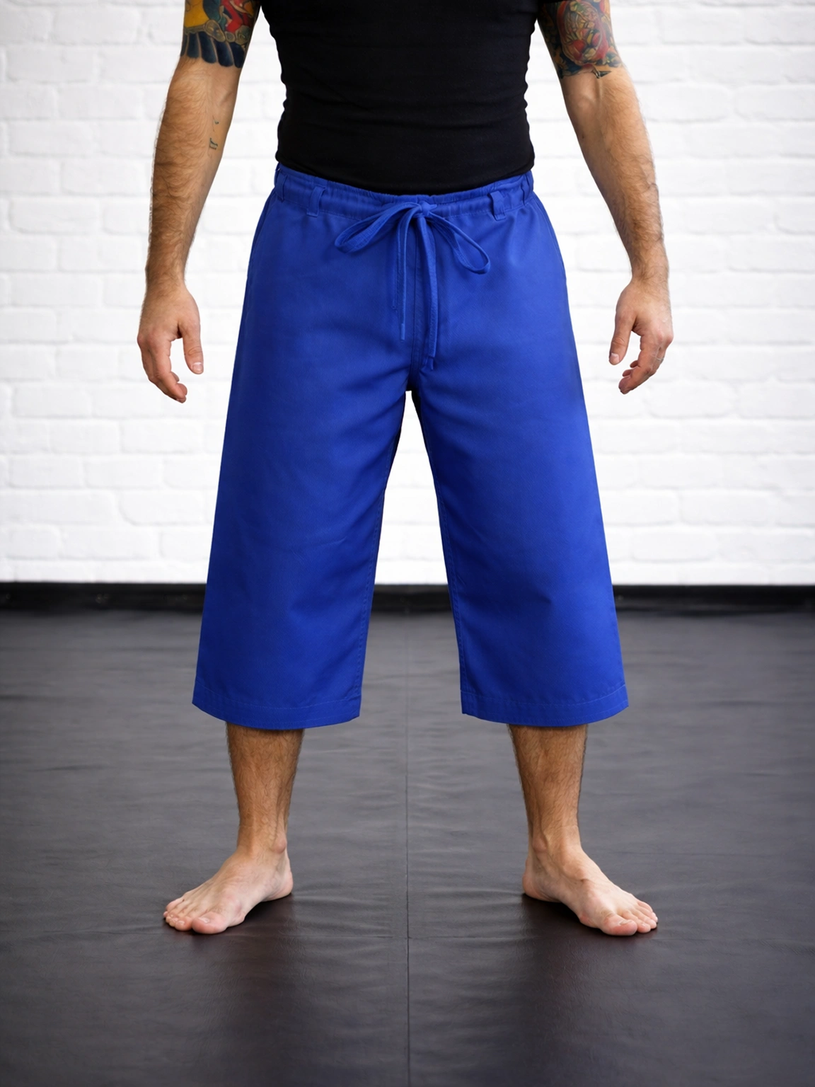 Синие бриджи М4 на спортсмене: укороченный тренировочный крой ниже колена для свободы работы ногами