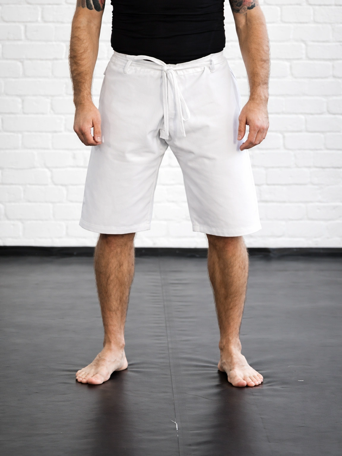 Белые шорты М5 на спортсмене: крой ровно прикрывает колено, обеспечивая свободу в динамике