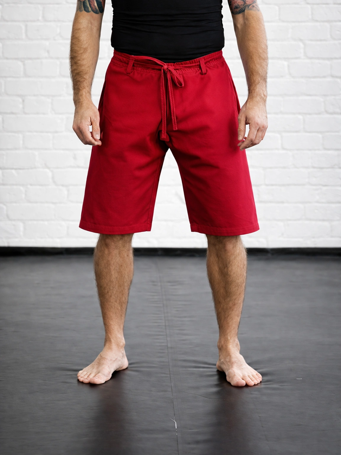 Красная модель М5 на завязках на спортсмене: узкий крой шорт для минимизации зацепов в кумитэ
