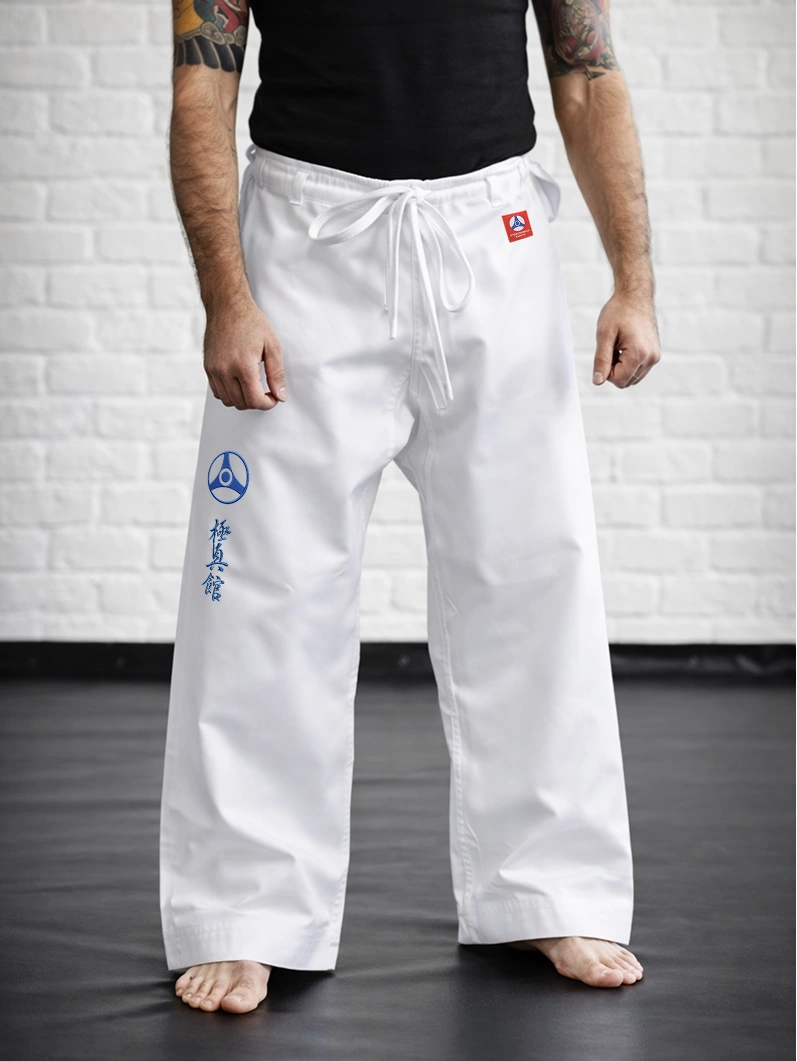 Спортсмен в белых штанах М1 Кёкусин-кан: демонстрация традиционной длины и иероглифа КАН.