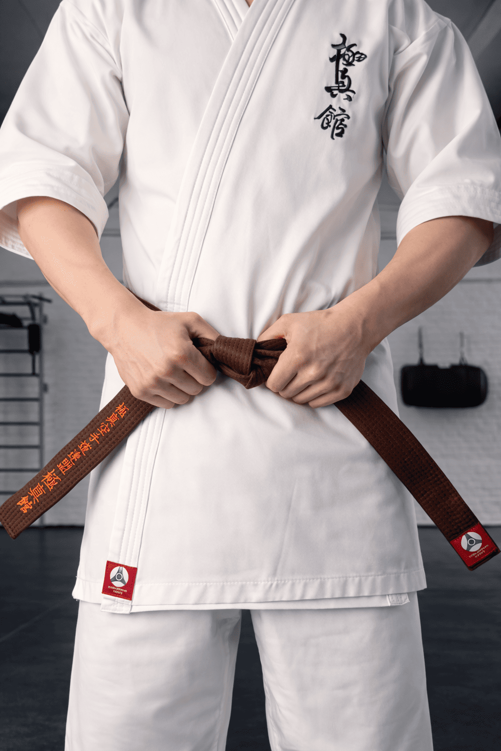 Мастер завязывает коричневый пояс КАН: символ зрелости и технического превосходства