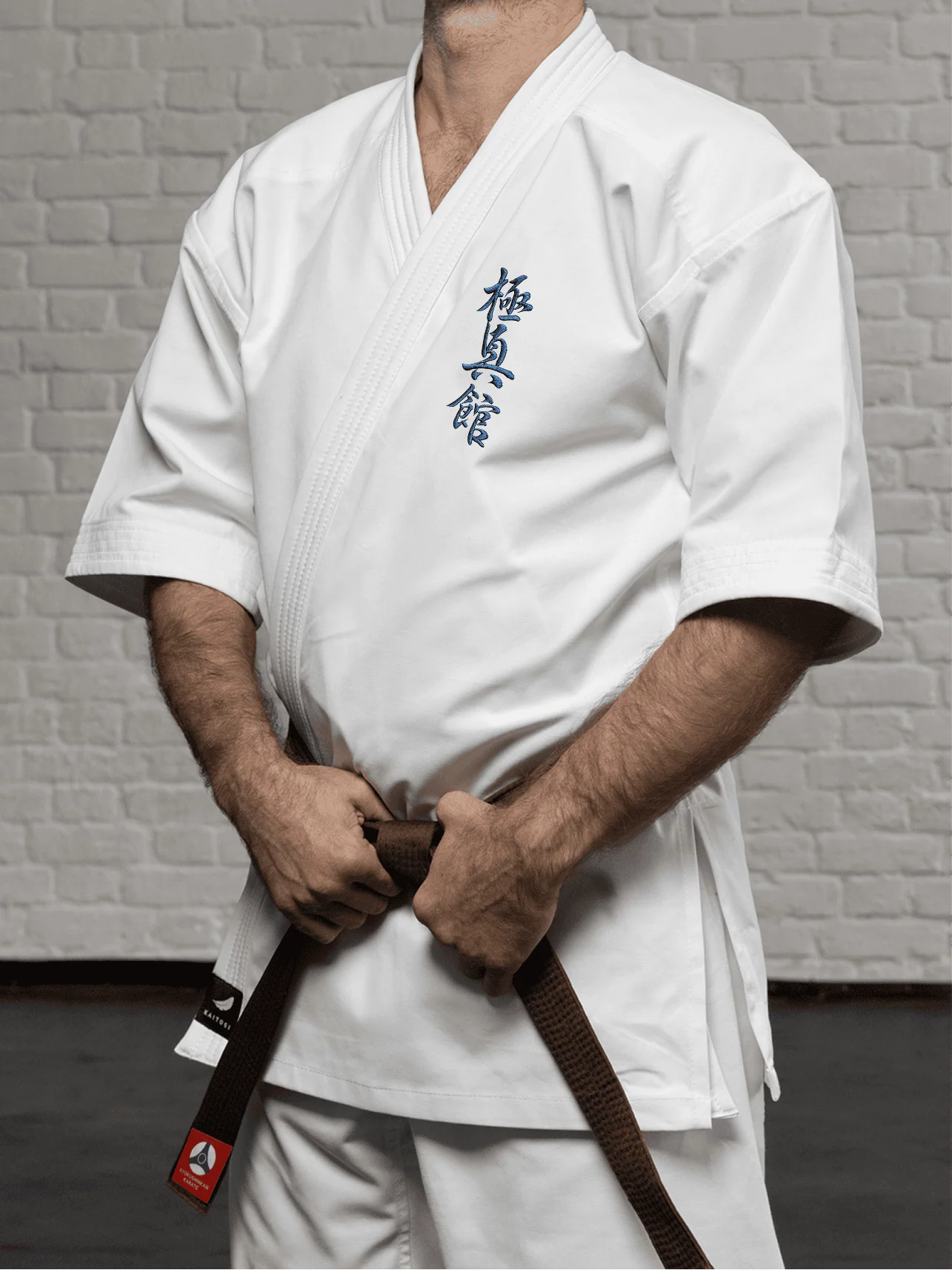 Белая куртка доги К4 стандарт на модели: укороченный подол, рукав ниже локтя и вышивка Кёкусин-кан на груди