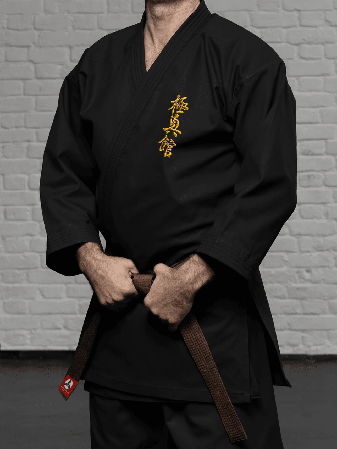 Чёрное доги К1–М2 стандарт на бойце: золотая вышивка Кёкусин-кан на груди и чёткая посадка по корпусу
