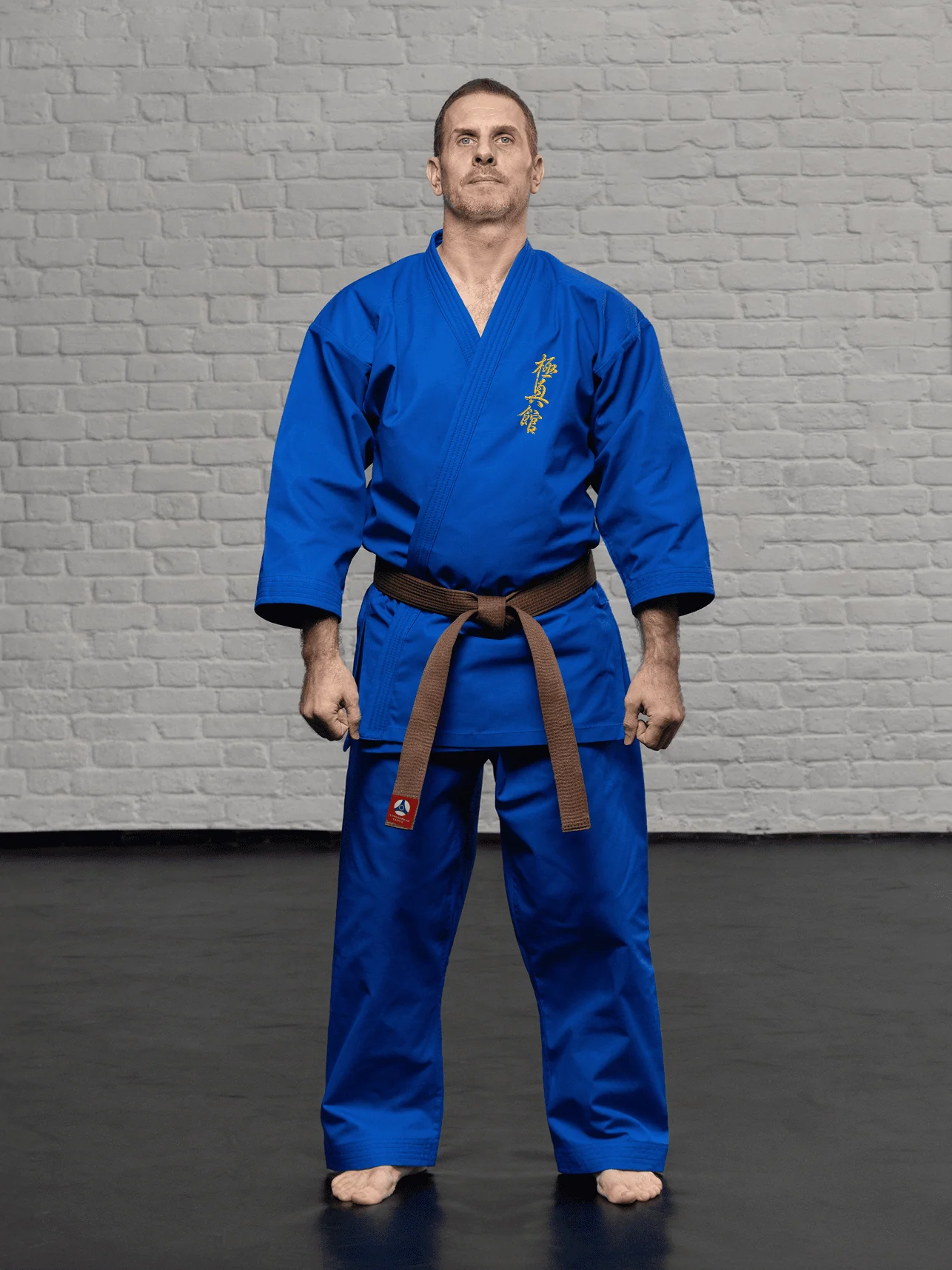 Синее кимоно для карате KAITOGI К3–М2 стандарт с золотой вышивкой Кёкусин-кан на груди: короткий подол и брюки ниже щиколотки