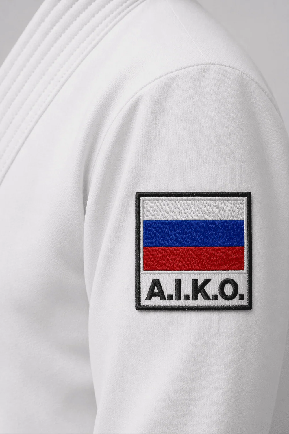 Шеврон A.I.K.O. с российским флагом на рукаве белого кимоно KAITOGI