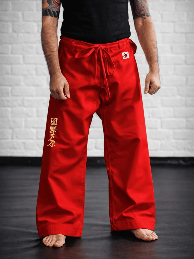 Красные штаны AIKO М1 на модели: демонстрация длины до пола, золотой вышивки и фирменной отделки